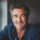 Homme souriant, cheveux gris, chemise bleue
